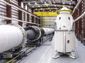 In this Dec. 18, 2018 photo provided by SpaceX, SpaceX's Crew Dragon spacecraft and Falcon 9 rocket are positioned inside the company's hangar at Launch Complex 39A at NASA's Kennedy Space Center in Florida, ahead of the Demo-1 unmanned flight test.
