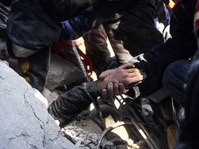 Syrian civil defence workers rescue a child from under the rubble of a collapsed five-storey building in the Salah al-Din district of the northern city of Aleppo on Feb. 2, 2019.