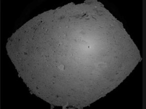 This Oct. 25, 2018, image provided by the Japan Aerospace Exploration Agency (JAXA) shows asteroid Ryugu. Japanese spacecraft Hayabusa2 is approaching the surface of an asteroid about 280 million kilometers (170 million miles) from Earth. The JAXA said Thursday, Feb. 21, 2019, that Hayabusa2 began its approach at 1:15 p.m. Hayabusa2's shadow is seen at center right over Ryugu. (JAXA via AP)