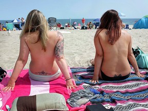 In this Aug. 26, 2017 file photo, women go topless as they participate in the Free the Nipple global movement during Go Topless Day at Hampton Beach, N.H.