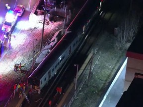 In this image taken from video provided by WNYW-TV, first responders work the scene of a collision between a commuter train and a motor vehicle in Westbury, N.Y., Tuesday, Feb. 26, 2019. (WNYW-TV via AP)