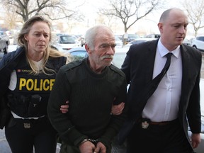 Police escort Michael Wentworth, 65, of Kingston into court for a bail hearing in Kingston, Ont. on Friday, Feb. 15, 2019. Wentworth is charged with nine crimes, including three counts of first-degree murder dating back to the mid 1990s and 2001.