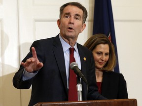 Virginia Gov. Ralph Northam, left, accompanied by his wife, Pam, speaks during a news conference in the Governor's Mansion in Richmond, Va., on Saturday, Feb. 2, 2019. (AP Photo/Steve Helber)