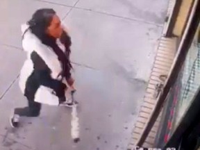 In this Jan. 15, 2019 image taken from surveillance video, a woman smashes the windows of "Back Home Restaurant" in the Bronx borough of New York. Police say that she became upset after ordering a patty and was told that the restaurant had run out of them. She returned with a bat and smashed two windows. (New York City Police Department via AP) ORG XMIT: NYR103
