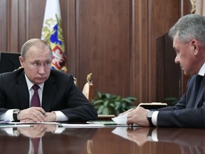 Russian President Vladimir Putin, left, speaks to Defence Minister Sergei Shoigu during a meeting in the Kremlin in Moscow, Russia, Saturday, Feb. 2, 2019.