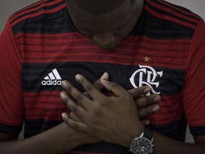 A man wearing a Flamengo soccer kit, prays during a memorial Mass for the victims of a fire at a Brazilian soccer academy, in Rio de Janeiro, Brazil, Friday, Feb. 8, 2019. A fire early Friday swept through the sleeping quarters of an academy for Brazil's popular professional soccer club Flamengo, killing 10 people and injuring three, most likely teenage players, authorities said.