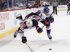 Oilers’ Connor McDavid is held back by the Islanders’ Brock Nelson. How long will McDavid put up with all the losing in Edmonton? Only he knows.