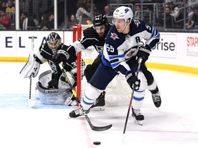 Mark Scheifele of the Winnipeg Jets keeps the puck from Derek Forbort of the Los Angeles Kings and Jack Campbell during the first period at Staples Center on March 18, 2019 in Los Angeles.