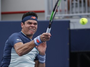 Milos Raonic returns a volley to Kyle Edmund during the Miami Open tennis tournament, Sunday, March 24, 2019, in Miami Gardens, Fla. (AP Photo/Joel Auerbach