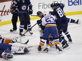 New York Islanders' Casey Cizikas (53) checks Winnipeg Jets' Mark Scheifele (55) over the back of Islanders' Adam Pelech (3) during Thursday's game. (THE CANADIAN PRESS)