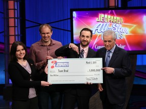 This photo provided by Sony shows Brad Rutter, Larissa Kelly and David Madden with Alex Trebek, winners of the first-ever "Jeopardy!" team championship, Tuesday, March 5, 2019 in in Burbank, Calif. (Carol Kaelson /Sony via AP)