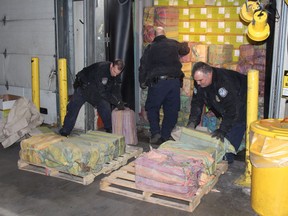This Feb. 28, 2019 photo provided by U. S. Customs and Border Protection shows Customs agents unloading a truck containing 3,200 pounds of cocaine in 60 packages, where it was seized at the Port of New York/Newark, in Newark, N.J.  (U.S. Customs and Border Protection via AP)