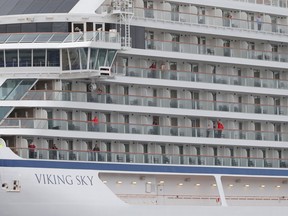 Passengers aboard the cruise ship Viking Sky, that ran into trouble in stormy seas off Norway, waves as the ship reaches the port of Molde under its own steam on March 24, 2019. (SVEIN OVE EKORNESVAAG/AFP/Getty Images)