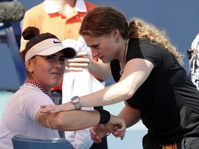 Bianca Andreescu, left, receives medical treatment from Lisa Pataky, of the WTA, during her match against Anett Kontaveit during the Miami Open, Monday, March 25, 2019, in Miami Gardens, Fla. (AP Photo/Lynne Sladky)