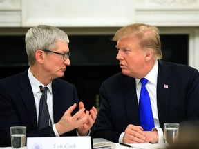U.S. President Donald Trump talks to Apple Inc. CEO Tim Cook during the American Workforce Policy Advisory Board's first meeting in the State Dining Room of the White House in Washington on Wednesday, March 6, 2019.