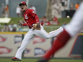 Reds second baseman Scooter Gennett shouts as he is unable to make a bare-handed grab on an infield hit by Royals' Humberto Arteaga during the fourth inning of a spring training game Thursday, March 21, 2019, in Goodyear, Ariz.
