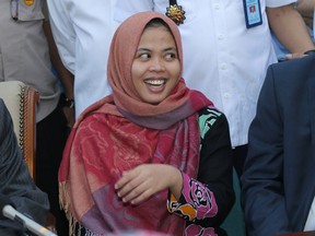 Indonesian Siti Aisyah smiles during a press conference upon returning home from Malaysia at Halim Perdanakusumah Airport in Jakarta, Indonesia, Monday, March 11, 2019. (AP Photo/Tatan Syuflana)