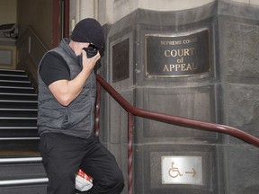 Workplace bullying claimant David Hingst covers his face as he leaves the Court of Appeal in Melbourne, Australia Friday, March 29, 2019. The Australian appeals court on Friday dismissed a bullying case brought by the engineer Hingst who accused his former supervisor of repeatedly breaking wind toward him.