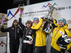 Germany's Thorsten Margis, third left, and Francesco Friedrich, right, hold up the trophy after winning the two-man bobsleigh event at the Bobsleigh World Championships while posing for a photograph with second-place finishers, Canada's Cameron Stones, left, of Whitby, Ont., and Justin Kripps, second left, of Summerland, B.C., in Whistler, B.C., on Saturday, March 2, 2019.