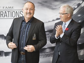 Seven time Stanley Cup winner Bryan Trottier, left, is applauded by the chair of the Board of Governors for Canadian Sports Hall of Fame Colin MacDonald, after being presented with his jacket, following his induction into Canada's Sports Hall of Fame , in Toronto on Tuesday, November 1, 2016. (THE CANADIAN PRESS/Chris Young)