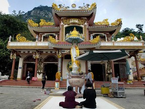 Women sit praying in front of a buddhist pagoda on the flank of Nui Ba Den (Ba Den Mountain) in Vietnam. (HOANG DINH NAM/AFP/Getty Images)