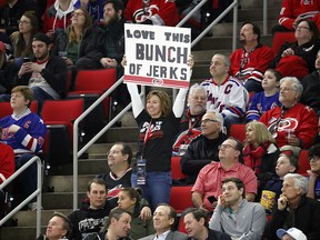 A Carolina Hurricanes fan holds a sign saying she loves this "Bunch of Jerks" during a gameagainst the New York Rangers in Raleigh, N.C., Tuesday, Feb. 19, 2019. (AP Photo/Chris Seward)