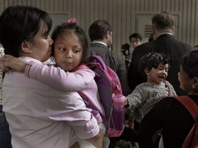 Asylum seekers, from left, Vanessa Mae Rodel and daughter Keana, Nadeeka Dilrukshi Nonis and her son Dinath stand during a press conference outside the building of Hong Kong's immigration department in Hong Kong, Monday, May 15, 2017.