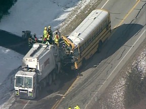 In this image made from a Wednesday, March 6, 2019, video provided by WCPO-TV a school bus collides with a garbage truck near Aurora, Ind, a city about 30 miles west of Cincinnati. Authorities say multiple students were hurt in the accident. (WCPO-TV via AP)