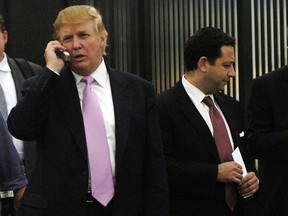 In this Sept. 14, 2005, file photo, Donald Trump, left, talks on his cellphone with Felix Sater, right, outside after speaking at the Bixpo 2005 business convention at the Budweiser Events Center in Loveland, Colo.