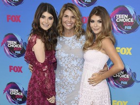 In this Aug. 13, 2017 file photo, actress Lori Loughlin, centre, poses with her daughters Bella, left, and Olivia Jade at the Teen Choice Awards in Los Angeles.