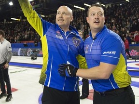 Team Alberta skip Kevin Koe (left) celebrates his win over Team Wild Card with lead Ben Hebert in the final draw at the Brier in Brandon, Man. Sunday, March 10, 2019.