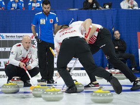 Canada skip Kevin Koe calls for the sweep as Italy lead Simone Gonin looks on at the world men's curling championship in Lethbridge, Alta. on Sunday, March 31, 2019.