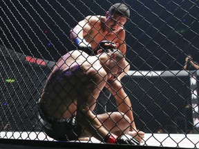 Mixed martial arts (MMA) fighters Russia's Timofey Nastyukhin ,top, delivers his right to Eddie Alvarez of the Unites States during their lightweight world grand prix quarterfinal of One Championship bout in Tokyo, Sunday, March 31, 2019. (AP Photo/Koji Sasahara)