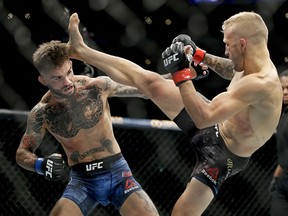 T.J. Dillashaw, right, kicks Cody Garbrandt during their bantamweight bout at UFC 227 in Los Angeles, Saturday, Aug. 4, 2018. (AP Photo/Chris Carlson)