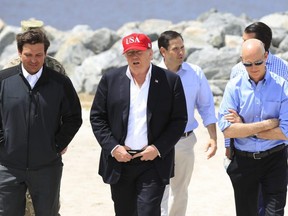 U.S. President Donald Trump walks with, from left, Florida Gov. Ron DeSantis, Sen. Marco Rubio, R-Fla., and Sen. Rick Scott, R-Fla., during a visit to Lake Okeechobee and Herbert Hoover Dike at Canal Point, Fla., Friday, March 29, 2019.