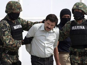 In this Feb. 22, 2014 file photo, Joaquin "El Chapo" Guzman, center, is escorted to a helicopter in handcuffs by Mexican navy marines at a hanger in Mexico City, after he was captured overnight in the beach resort town of Mazatlan. Defense attorneys asked a federal judge Tuesday, March 26, 2019, to grant a new trial to El Chapo, saying jurors improperly followed media coverage of the sensational drug conspiracy case.