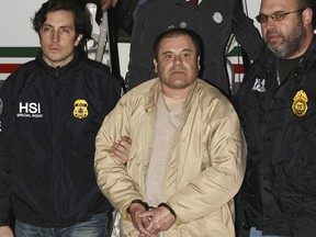 In this Jan. 19, 2017, file photo, authorities escort Joaquin "El Chapo" Guzman, centre, from a plane to a waiting caravan of SUVs at Long Island MacArthur Airport in Ronkonkoma, N.Y. (United States Drug Enforcement Administration via AP, File)