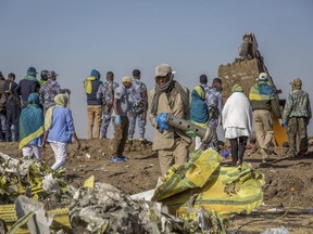 Workers gather at the scene of an Ethiopian Airlines flight crash near Bishoftu, or Debre Zeit, south of Addis Ababa,  Ethiopia, Monday, March 11, 2019.