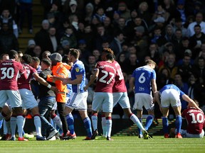 A fan is removed after attacking Aston Villa's Jack Grealish, right, on the pitch during the Sky Bet Championship soccer match at St Andrew's Trillion Trophy Stadium, Birmingham, England, Sunday March 10, 2019.