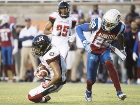 Ottawa Redblacks' Noel Thomas Jr., left, goes in for a touchdown as Montreal Alouettes' Jermaine Robinson misses the tackle during first half CFL football action in Montreal, Friday, July 6, 2018.