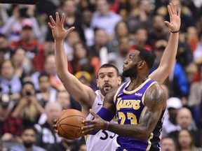 Raptors’ Marc Gasol (left) tries to block Lakers’ LeBron James during Thursday’s game in Toronto. (THE CANADIAN PRESS)