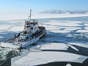 Departing ship among the ice floes on lake Baikal in Listvyanka. The mouth of the Angara.