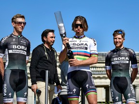 Slovakian Peter Sagan of Bora-Hansgrohe (C) holds a t-shirt launcher  on stage during the team presentation n April 8, 2017 on the eve of the Paris-Roubaix cycling race in Compiegne, northern France.