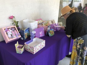 A woman looks a display of mementos at the funeral service for Trinity Love Jones, the 9-year-old whose body was found this month stuffed in a duffel bag along an equestrian trail, at St. John Vianney Catholic Church in Hacienda Heights, Calif., Monday, March 25, 2019.