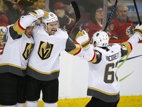 Vegas Golden Knights' Mark Stone, centre, celebrates his goal with teammates during second period NHL hockey action against the Calgary Flames in Calgary, Sunday, March 10, 2019.