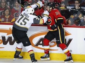 Vegas Golden Knights' Ryan Reaves, left, checks Calgary Flames' Garnet Hathaway during third period NHL hockey action in Calgary, Sunday, March 10, 2019. THE CANADIAN PRESS/Jeff McIntosh