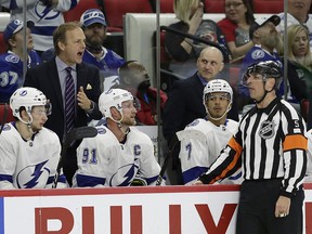 Tampa Bay Lightning coach Jon Cooper, upper left, speaks with an official, front right, during a game against the Carolina Hurricanes in Raleigh, N.C., Thursday, March 21, 2019. (AP Photo/Gerry Broome