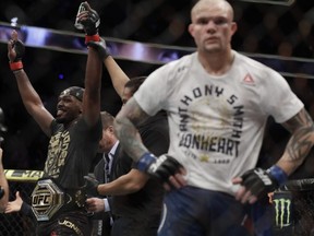Jon Jones (left) celebrates after defeating Anthony Smith (right) following their light heavyweight title bout during UFC 235 at T-Mobile Arena in Las Vegas on Saturday, March 2, 2019.