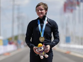 In this Wednesday, July 22, 2015 file photo, United States gold medallist Kelly Catlin poses after winning the women's individual time trial cycling competition at the Pan Am Games in Milton, Ontario. (AP Photo/Felipe Dana, File)