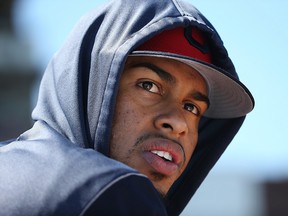 An injured Cleveland Indians shortstop Francisco Lindor watches teammates from the dugout during the second inning of a spring training baseball game against the San Diego Padres, Monday, March 18, 2019, in Goodyear, Ariz.